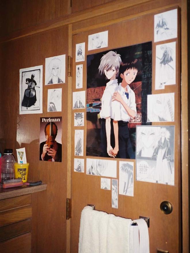 A wooden door covered in a collage of manga images from Rurouni Kenshin and a poster from the anime Neon Genesis Evangelion