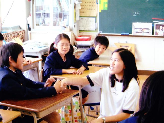 I shake the hand of Japanese elementary school student during an English-language game.