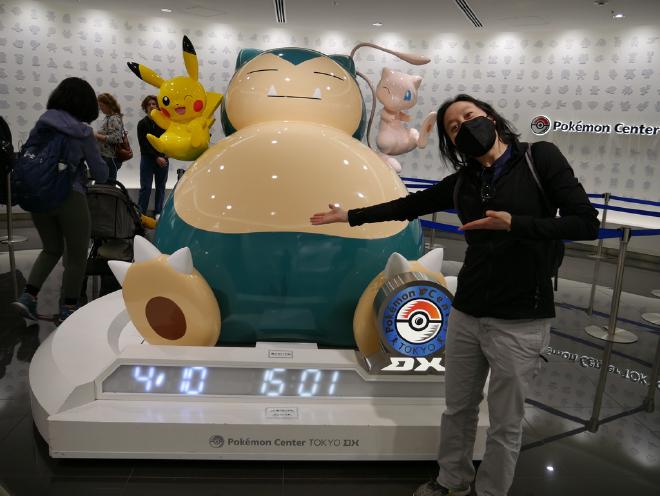 Van stands beside a giant pokemon figurine at Pokemon Center Tokyo DX