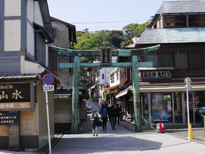 A few people enter Benzaiten Nakamise Dori, the island&rsquo;s main avenue.