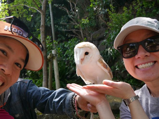 Van and I pose with an owl held up by its handler between us.