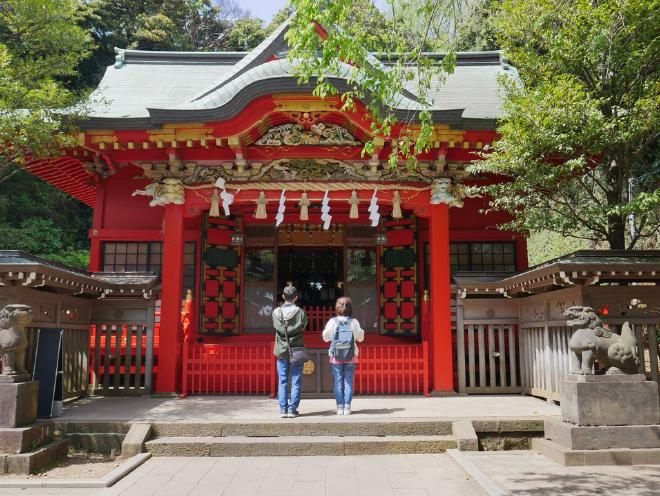 Two people pay their respects to one of the shrines on the island.