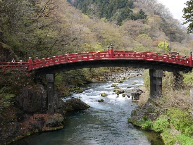 The red Shinkyo Bridge standing over a stream.