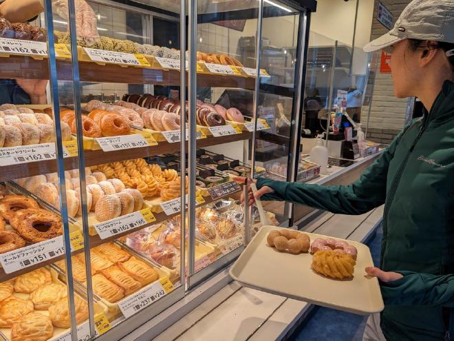 Van selects her donuts from a self-serve shelf at Mister Donut.